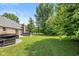 Spacious backyard with a manicured lawn, mature trees, grilling area and a hot tub at 12661 Doe Ln, Indianapolis, IN 46236