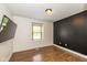 Bedroom with hardwood floors, a window with blinds, and a dark paneled wall at 12661 Doe Ln, Indianapolis, IN 46236