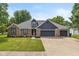 Charming single-story home featuring a well-manicured lawn, brick accents and a spacious three car garage at 12661 Doe Ln, Indianapolis, IN 46236