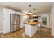 Modern kitchen with stainless steel appliances, a center island, white cabinetry, and hardwood floors at 12661 Doe Ln, Indianapolis, IN 46236