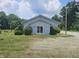 Light gray building with green lawn and parking area with some trees surrounding at 1267 W 750 S, Trafalgar, IN 46181