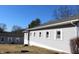 A one-story building with light gray siding and white-framed windows, set against a clear blue sky at 1267 W 750 S, Trafalgar, IN 46181