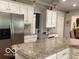 Bright kitchen featuring white cabinetry, granite countertops, and stainless fridge at 1273 Helford Ln, Carmel, IN 46032