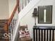 Inviting stairway with wood handrail and decorative mirror and lamp at 1273 Helford Ln, Carmel, IN 46032