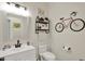 Charming half bathroom featuring a white vanity, decorative bike accents, and modern fixtures at 1377 Sedona Dr, Carmel, IN 46032