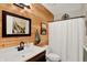 Bathroom featuring wood accent wall, modern vanity, and neutral fixtures providing a rustic charm at 1377 Sedona Dr, Carmel, IN 46032