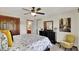 Bedroom with white walls, a ceiling fan, a comfortable bed with decorative pillows, and a classic wood dresser at 1377 Sedona Dr, Carmel, IN 46032