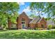 A stately brick home with a manicured lawn, arched entryway, and lush landscaping offering classic curb appeal at 1377 Sedona Dr, Carmel, IN 46032