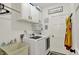 Well-equipped laundry room featuring a washing machine, dryer, sink, storage cabinets and closet at 1377 Sedona Dr, Carmel, IN 46032