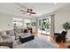 Comfortable living room featuring sliding glass doors, hardwood floors, a ceiling fan, and access to the kitchen at 1377 Sedona Dr, Carmel, IN 46032