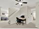 A functional office space featuring neutral walls, carpet and staircase, and a comfortable seating area in the background at 1377 Sedona Dr, Carmel, IN 46032