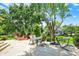 Inviting patio with a dining set, fire pit, and lounge chairs, surrounded by mature trees and lush greenery at 1377 Sedona Dr, Carmel, IN 46032