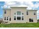 Spacious backyard view of a beige two-story home, showcasing ample windows and outdoor patio seating at 1414 W Springhurst Blvd, Greenfield, IN 46140
