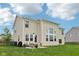 Large two-story home featuring a backyard patio, multiple windows, and lush green lawn at 1414 W Springhurst Blvd, Greenfield, IN 46140
