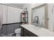 Well-lit bathroom featuring a modern vanity, decorative shelving, and a stylish striped shower curtain at 1414 W Springhurst Blvd, Greenfield, IN 46140