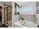 Primary bathroom featuring a glass-enclosed shower, a soaking tub, and neutral tile at 1414 W Springhurst Blvd, Greenfield, IN 46140