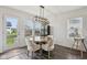 Bright dining area featuring a modern chandelier and a view to the fenced backyard at 1414 W Springhurst Blvd, Greenfield, IN 46140