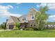 Beautifully landscaped front yard with a brick and siding exterior home with well-manicured lawn, showcasing curb appeal at 1414 W Springhurst Blvd, Greenfield, IN 46140