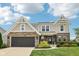 Charming two-story home with a brick and siding exterior and well-manicured lawn, showcasing curb appeal at 1414 W Springhurst Blvd, Greenfield, IN 46140