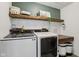 Bright laundry room featuring floating shelves, trendy decor, and modern Samsung washer and dryer at 1414 W Springhurst Blvd, Greenfield, IN 46140