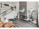 Spacious living room with fireplace, stylish decor, hardwood floors, and staircase, blending comfort and style at 1414 W Springhurst Blvd, Greenfield, IN 46140