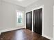 A bedroom displays a window for natural light, painted walls, and dark bi-fold closet doors at 1418 W 5Th St, Anderson, IN 46016