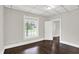 A neutral bedroom shows a window with natural light, dark wood floors, and painted walls at 1418 W 5Th St, Anderson, IN 46016