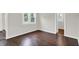 An empty bedroom features a window for natural light, painted walls, and dark wood floors at 1418 W 5Th St, Anderson, IN 46016
