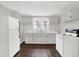 Well-lit kitchen with white cabinets, refrigerator, range, hardwood flooring, and a traditional aesthetic at 1418 W 5Th St, Anderson, IN 46016