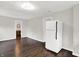 Open concept with hardwood flooring leading to a spacious kitchen with white refrigerator at 1418 W 5Th St, Anderson, IN 46016