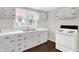 Clean kitchen features white cabinets, counters, and appliances, with hardwood floors, and a vintage touch at 1418 W 5Th St, Anderson, IN 46016