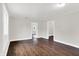 Open living space with hardwood floors, neutral walls, white trim, and multiple doorways to other rooms at 1418 W 5Th St, Anderson, IN 46016