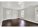 Bright living room featuring hardwood floors, fresh gray paint, white trim, and a backyard view from the door at 1418 W 5Th St, Anderson, IN 46016