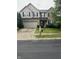 Two-story home featuring a brick and tan siding exterior, a two-car garage, and a well-manicured front yard at 14375 Leland Muse, Fishers, IN 46037