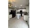 Spacious kitchen featuring white cabinets, black appliances, tile floors, and a center island with a marble countertop at 14375 Leland Muse, Fishers, IN 46037