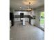 Well-lit kitchen with white cabinets, black appliances, a center island, and a view of the outdoor deck at 14375 Leland Muse, Fishers, IN 46037