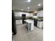 Bright kitchen featuring white cabinets, black appliances, tile floors, and a center island with a marble countertop at 14375 Leland Muse, Fishers, IN 46037