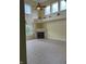 Bright living room featuring a soaring ceiling, ceiling fan, fireplace, and large windows with decorative curtains at 14375 Leland Muse, Fishers, IN 46037