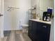 Bright bathroom featuring wood-style vinyl floor, toilet, and black vanity with white top at 1503 Quinlan Ct, Indianapolis, IN 46217