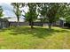 View of backyard with large trees, fence, green grass, shed and back of the house at 1504 Manhattan Ave, Indianapolis, IN 46241