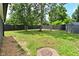 Large grassy backyard with privacy fence, mature trees, lawn and storage shed in the background at 1504 Manhattan Ave, Indianapolis, IN 46241
