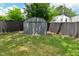 View of storage shed in backyard with black privacy fence and vibrant green lawn at 1504 Manhattan Ave, Indianapolis, IN 46241