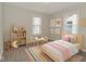 Charming bedroom with playful decor, including a striped rug, fun artwork, and adorable toys at 1504 Manhattan Ave, Indianapolis, IN 46241