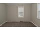 Well-lit bedroom featuring a window with white trim, neutral walls, plush carpet, and baseboard trim at 1504 Manhattan Ave, Indianapolis, IN 46241
