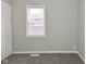 Bedroom with neutral walls and carpet featuring a window with white trim, a door and baseboard trim at 1504 Manhattan Ave, Indianapolis, IN 46241