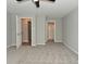 Open bedroom showcasing neutral walls, carpet, and entryways to the bathroom and closet at 1504 Manhattan Ave, Indianapolis, IN 46241
