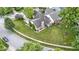 Aerial view of a brick home with a well-maintained lawn, landscaping, and neighboring pergola-covered deck at 15098 Newburyport Dr, Fortville, IN 46040