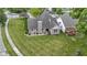 Aerial view of a brick home with a well-maintained lawn, landscaping, and neighboring pergola-covered deck at 15098 Newburyport Dr, Fortville, IN 46040