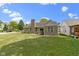 Expansive backyard featuring a brick home exterior, lush green lawn, and mature landscaping at 15098 Newburyport Dr, Fortville, IN 46040