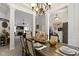 Open-concept dining room with decorative columns, elegant chandelier, and a view into the living room and entryway at 15098 Newburyport Dr, Fortville, IN 46040